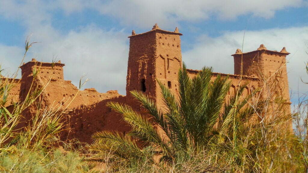 Kasbah towers among palm trees in a southern Moroccan oasis