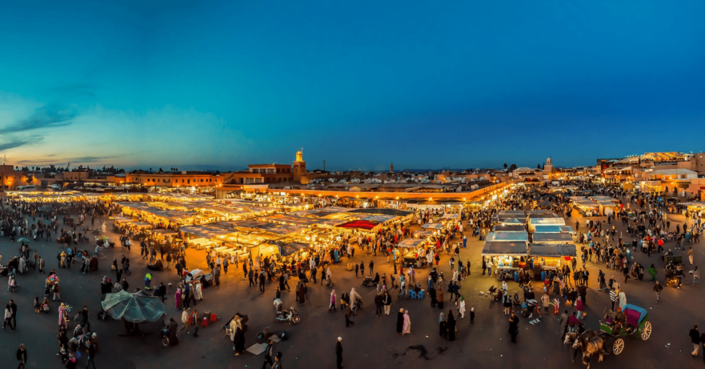 Jemaa el-Fnaa square lit up at dusk in Marrakech