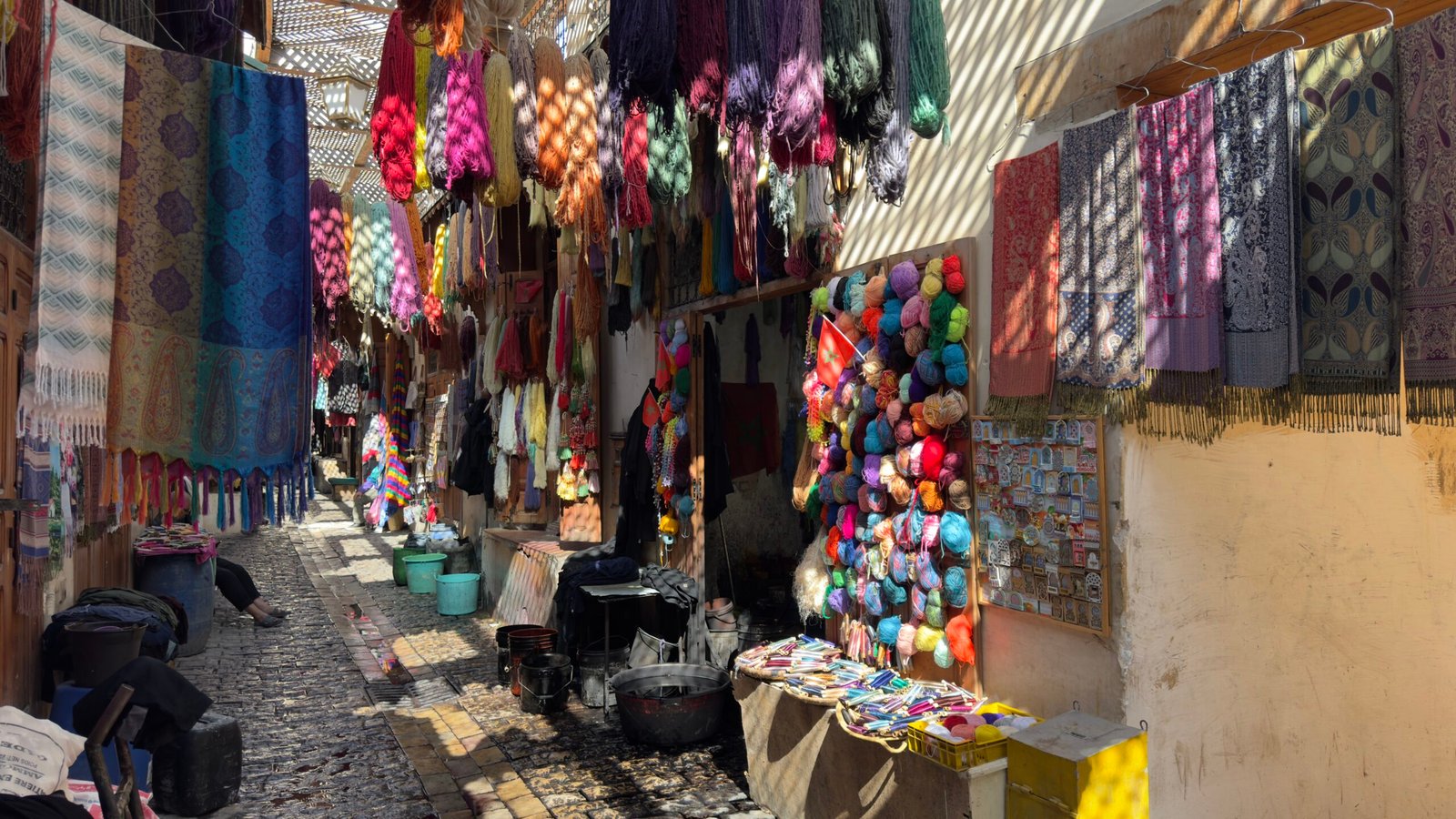 Textile souk alley with hanging scarves in the medina